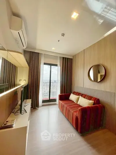 Modern living room with stylish decor and balcony view in a high-rise apartment.