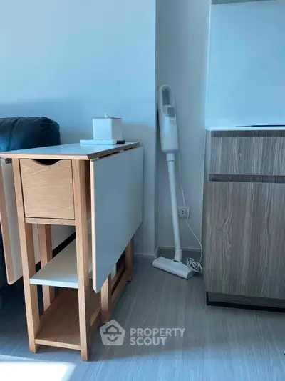 Modern living space with sleek furniture and a compact vacuum cleaner, showcasing minimalist design.