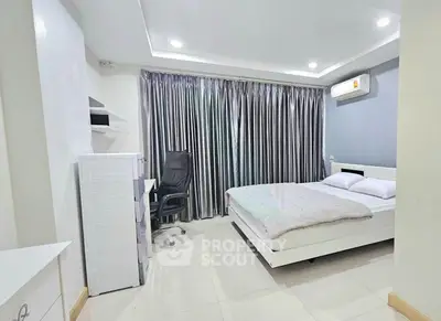 Modern bedroom with sleek design, featuring a comfortable bed, stylish curtains, and a workspace with a chair.