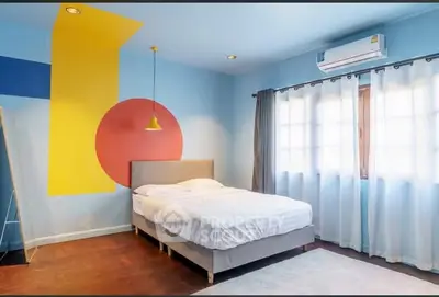 Modern bedroom with colorful geometric wall design and natural light