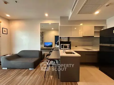 Modern open-layout living room and kitchen with sleek furniture and contemporary design.