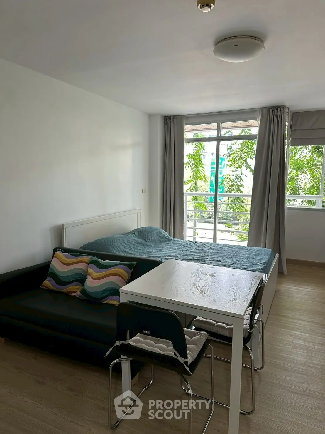 Cozy studio apartment with modern furnishings and large window for natural light.