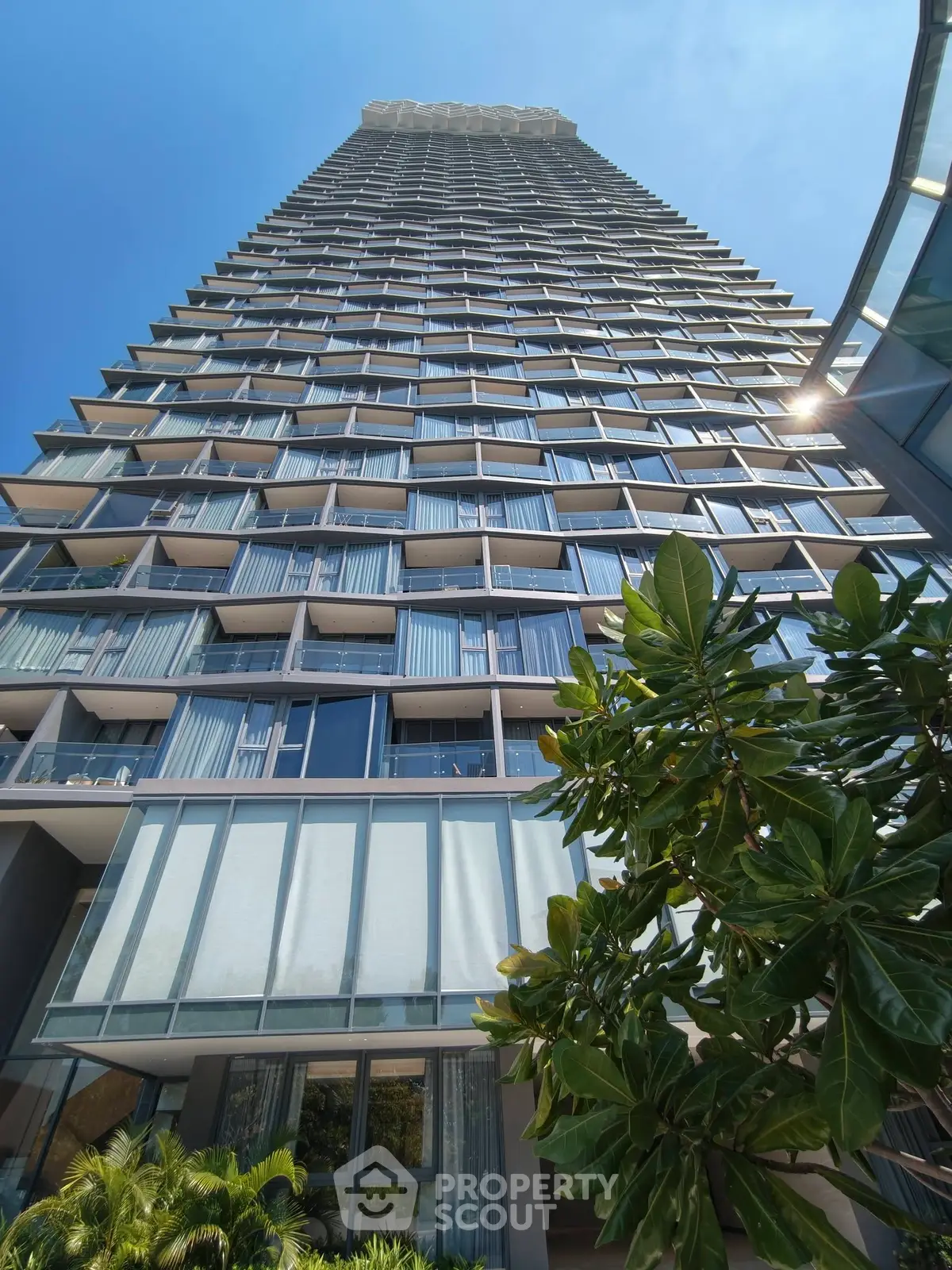 Stunning high-rise building with modern architecture and lush greenery, perfect for urban living.