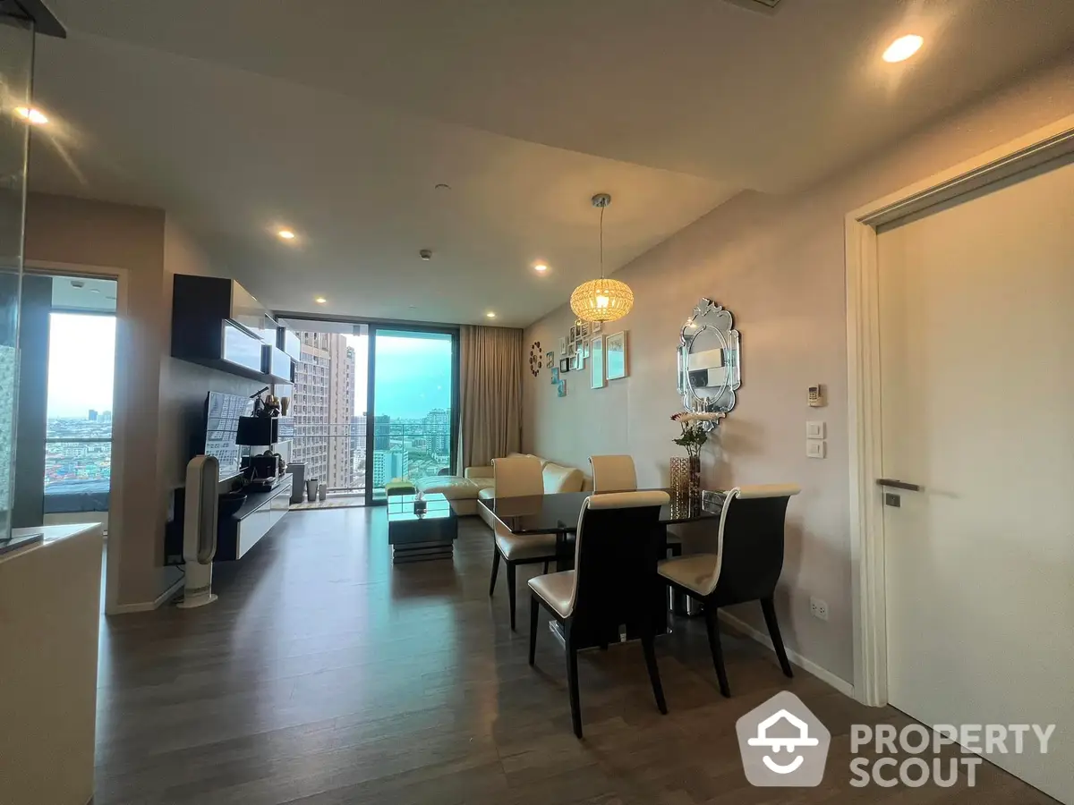 Spacious living room with modern furnishings, hardwood floors, and abundant natural light from floor-to-ceiling windows offering a stunning city view.