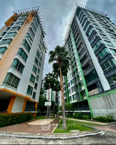 Modern residential buildings with lush greenery and basketball court