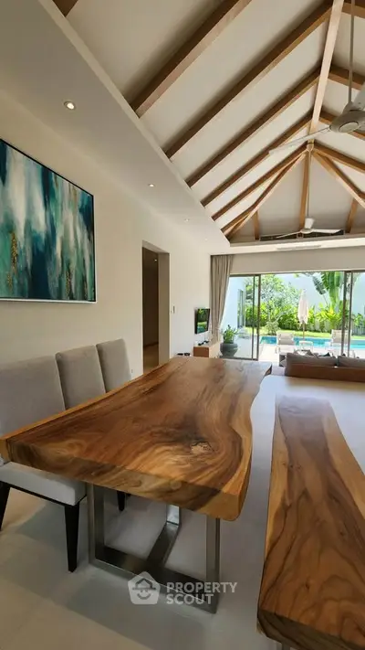 Luxurious open-plan living room with wooden dining table and pool view