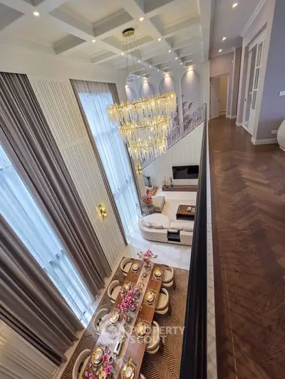 Luxurious double-height living room with elegant chandelier and dining area