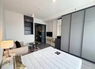 Modern bedroom with sleek furniture and ample storage in a stylish apartment.