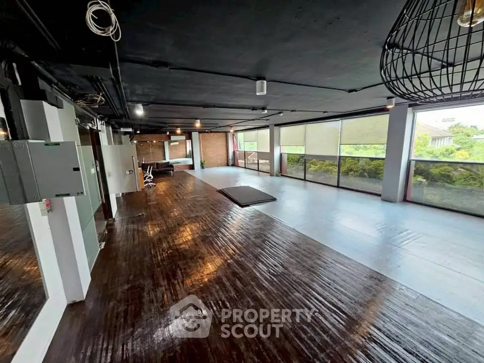 Spacious gym with modern equipment and large windows offering a scenic view, perfect for fitness enthusiasts.