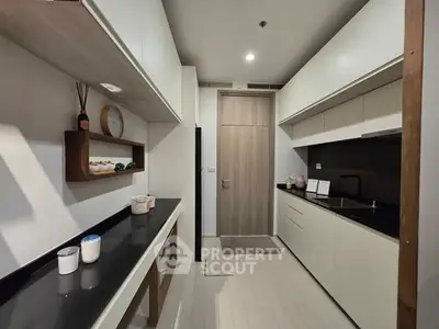 Modern kitchen with sleek cabinetry and black countertops in a contemporary apartment.