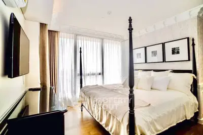 Luxurious bedroom with elegant four-poster bed and natural light from large windows.