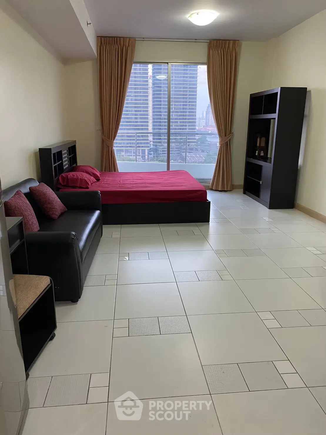 Spacious bedroom with city view, modern furnishings, and large windows for natural light.