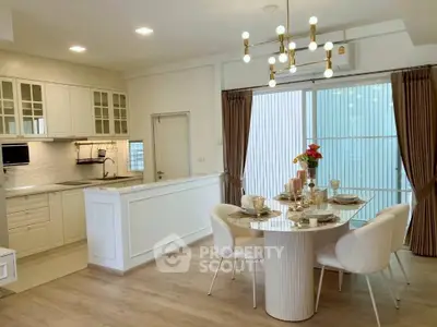 Elegant dining area with modern kitchen, featuring stylish lighting and chic decor.