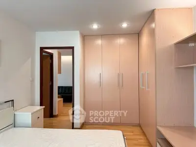 Spacious bedroom with built-in wardrobe and wooden flooring