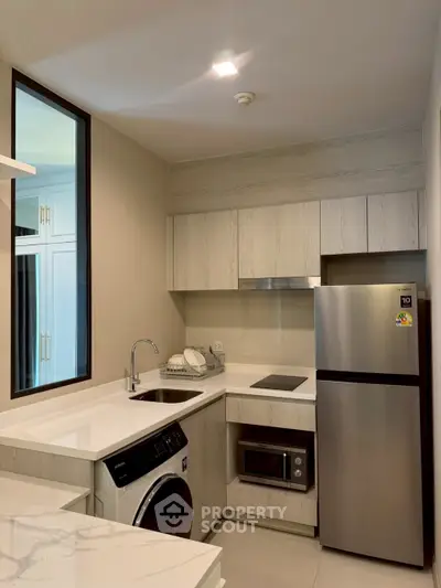 Modern kitchen with sleek appliances and stylish cabinetry in a compact layout.