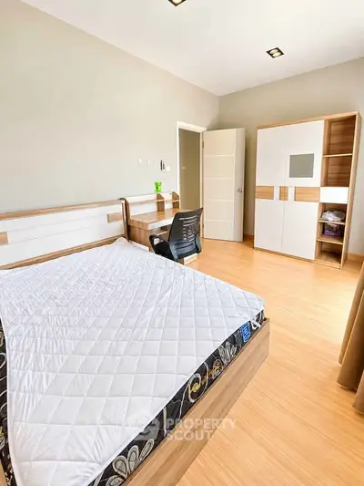 Spacious bedroom with modern furniture and natural light