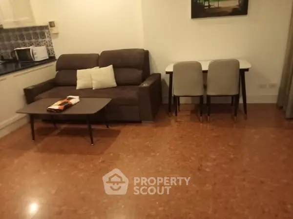 Cozy living room with modern sofa and dining table, perfect for relaxation and dining.