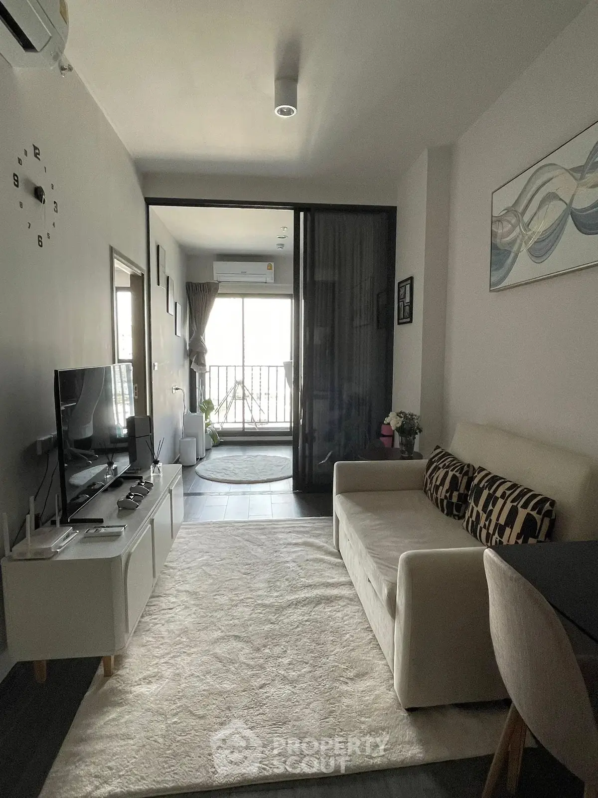 Modern living room with stylish decor and balcony access in a cozy apartment.