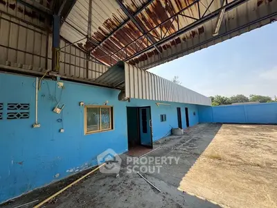Spacious industrial property with blue exterior and open courtyard, ideal for commercial use.