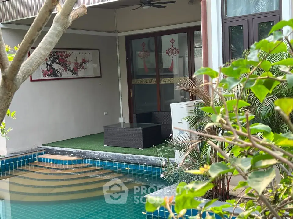Luxurious poolside patio with modern outdoor furniture and lush greenery.
