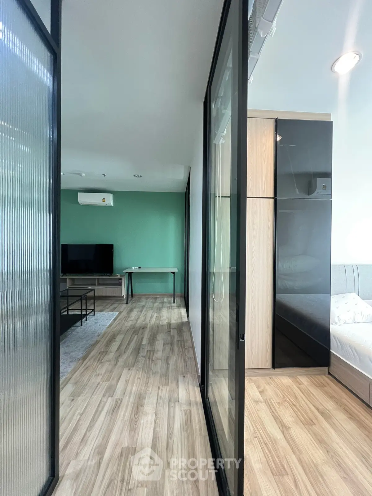 Modern apartment interior with glass partitions and wooden flooring