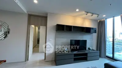 Modern living room with sleek TV unit and city view balcony