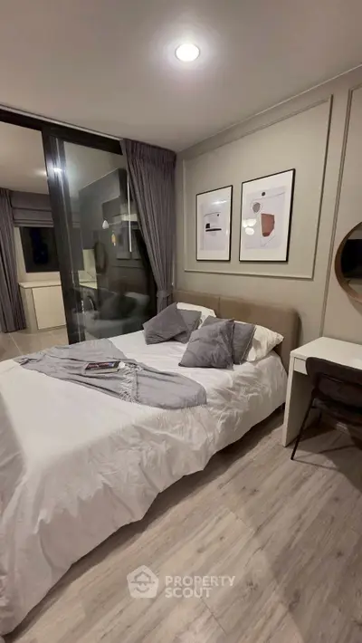 Modern bedroom with stylish decor and cozy ambiance, featuring elegant artwork and sleek furniture.