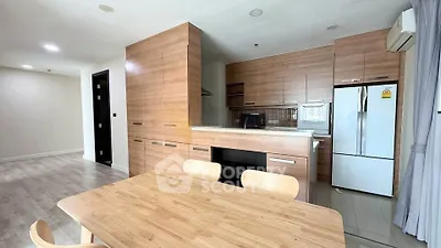 Modern kitchen with wooden cabinetry and dining area in open layout apartment