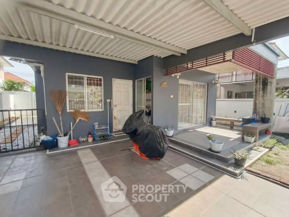 Spacious covered patio area with modern design and garden view, perfect for outdoor relaxation.