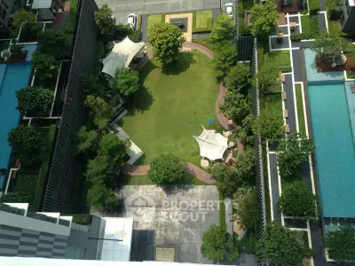Stunning aerial view of modern residential complex with lush garden and swimming pool.