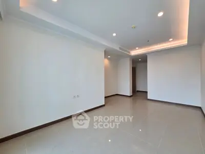 Spacious empty living room with modern lighting and tiled flooring