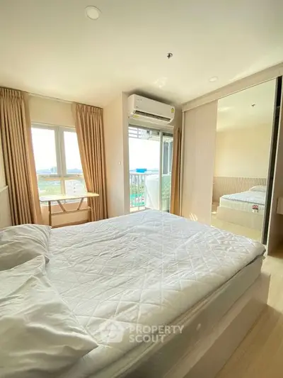 Bright and airy bedroom with large windows and mirrored closet doors, featuring a comfortable bed and air conditioning.