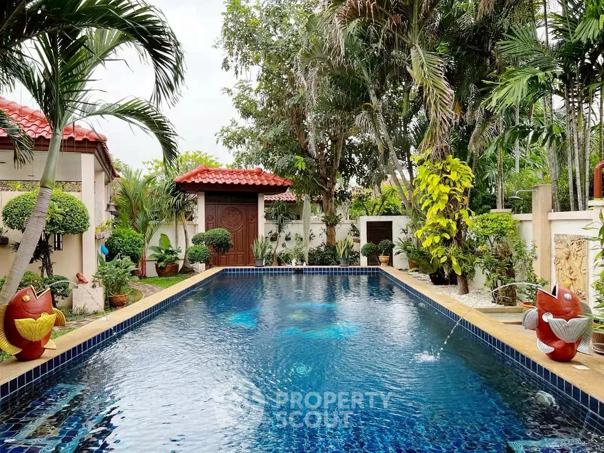 Luxurious tropical pool surrounded by lush greenery and elegant landscaping.
