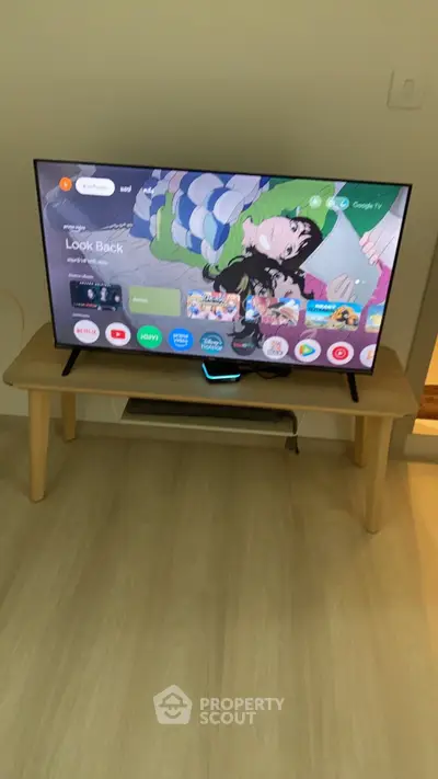 Modern living room with sleek TV setup on wooden stand, showcasing a cozy and stylish interior.