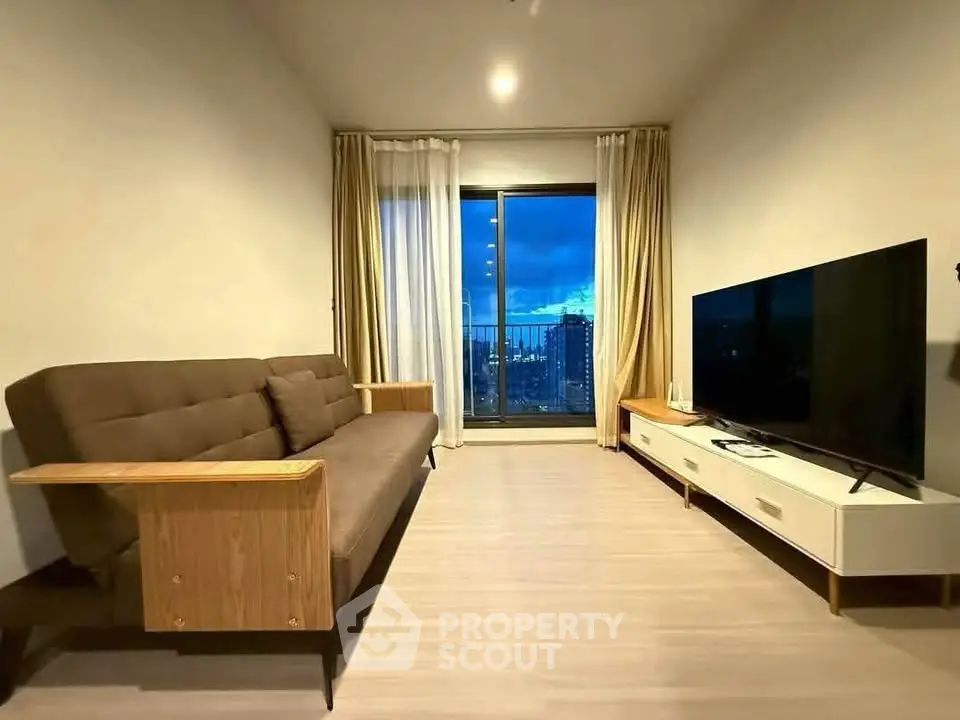Modern living room with sleek furniture and city view through large window.