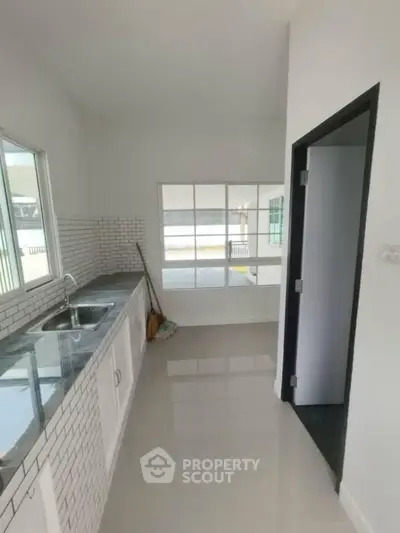 Modern kitchen with sleek countertops and white cabinetry in a bright, airy space.