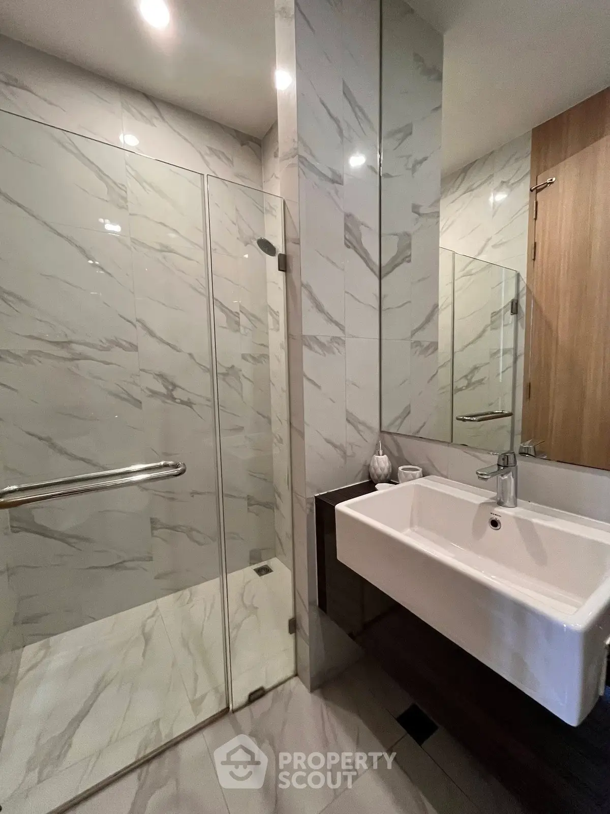 Modern bathroom with sleek marble tiles and glass shower enclosure