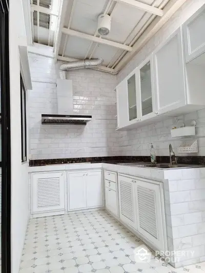 Bright modern kitchen with white cabinetry and tiled backsplash