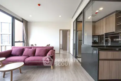 Modern open-plan living room with stylish kitchen and vibrant sofa