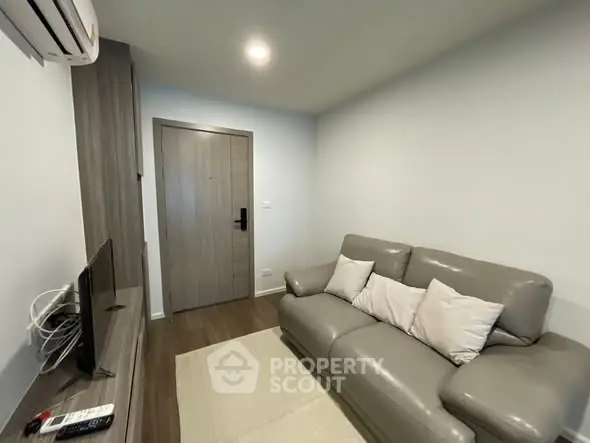 Cozy living room with modern sofa and TV setup, perfect for relaxation.