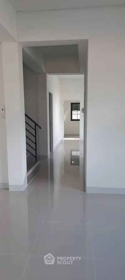 Spacious modern hallway with glossy tiled floors and minimalist design.