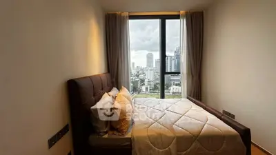 Cozy bedroom with stunning city view from large window, featuring a comfortable bed and elegant curtains.