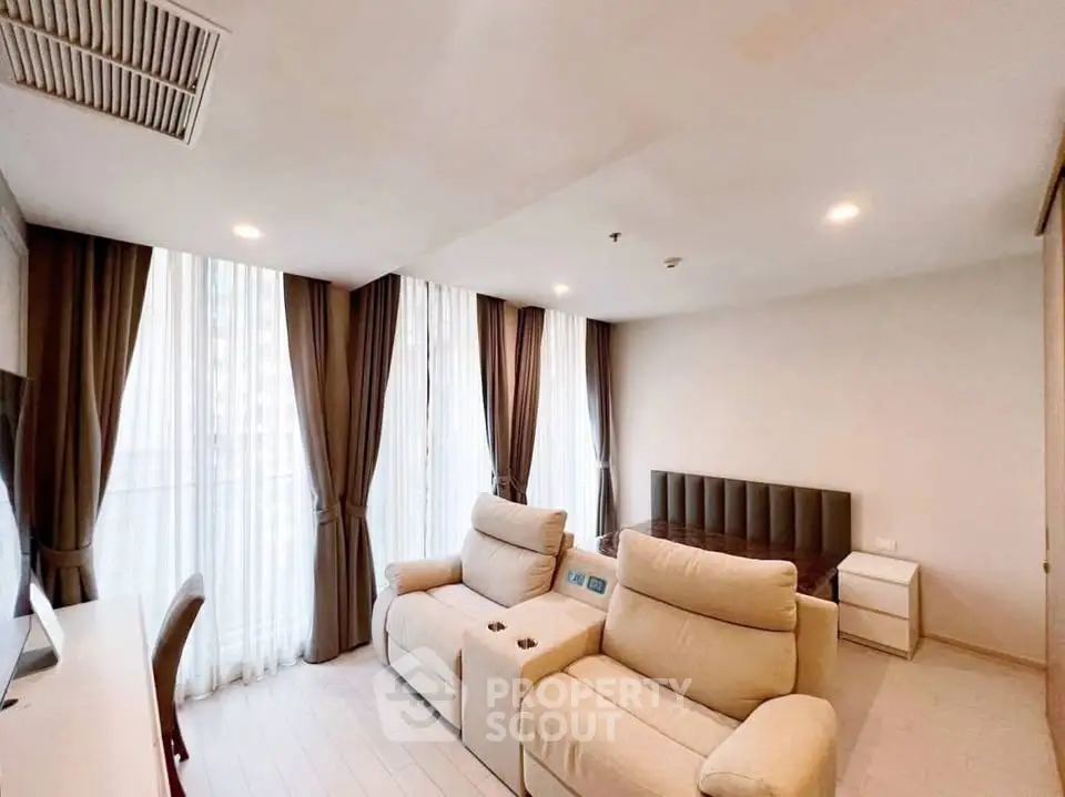 Modern living room with plush seating and large windows in a stylish apartment.