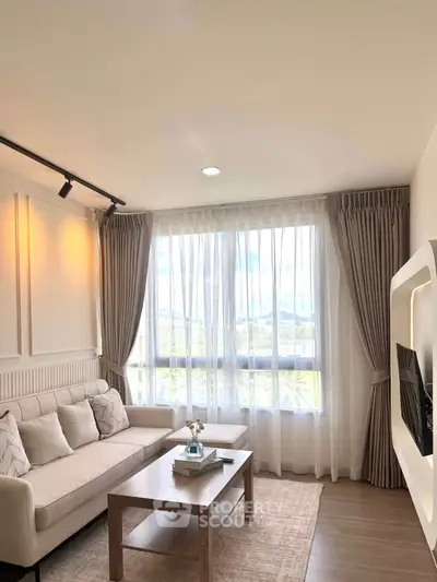 Bright and cozy living room with modern decor and large window view.