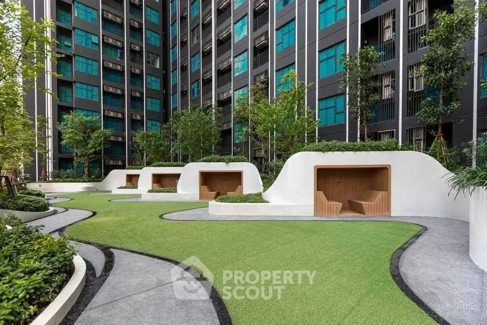 Modern apartment building with landscaped garden and unique seating areas.