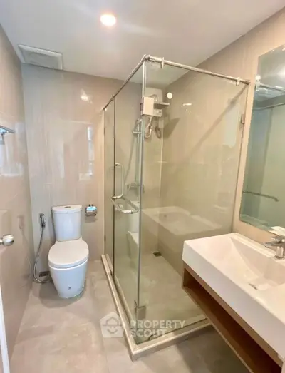 Modern bathroom with glass shower and sleek fixtures in a stylish apartment.