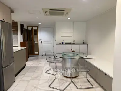 Modern kitchen with glass dining table and sleek appliances in open layout
