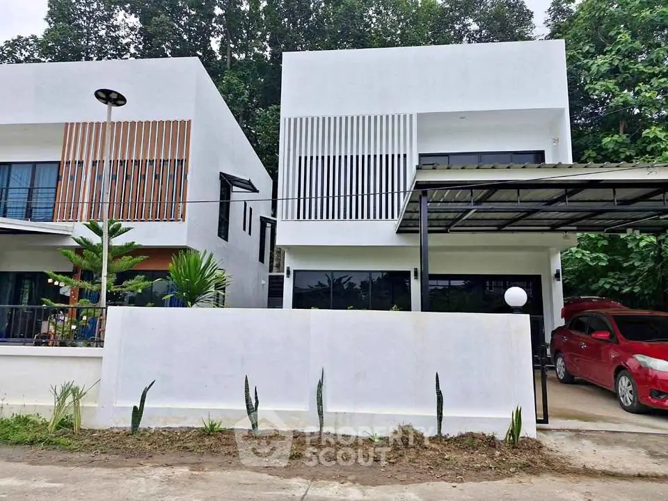 Modern two-story white house with carport and minimalist design in a serene neighborhood.