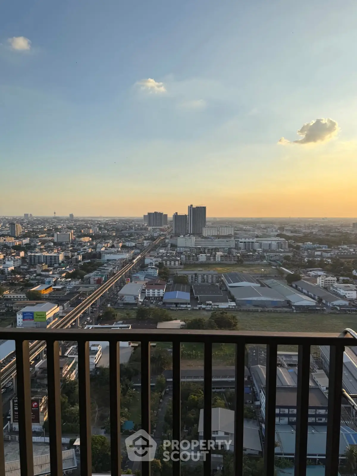 Stunning cityscape view from high-rise balcony at sunset, perfect for urban living enthusiasts.