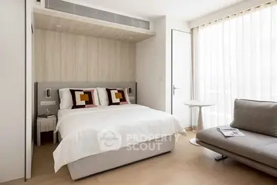Modern bedroom with stylish decor and natural light, featuring a cozy bed and elegant furnishings.